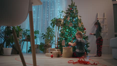 Zoomkamera:-Zwei-Jungen-Schmücken-Am-Heiligabend-Einen-Weihnachtsbaum-Und-Tragen-Weihnachtsbäume.-Hochwertiges-4K-Filmmaterial